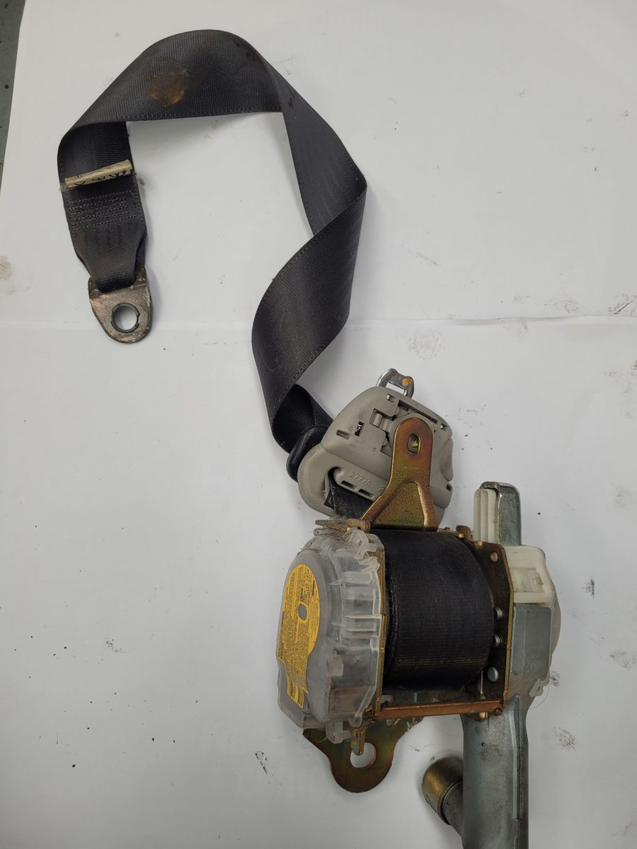 Removed Car Seat Belt Assembly Used car seat belt retractor and webbing on white background