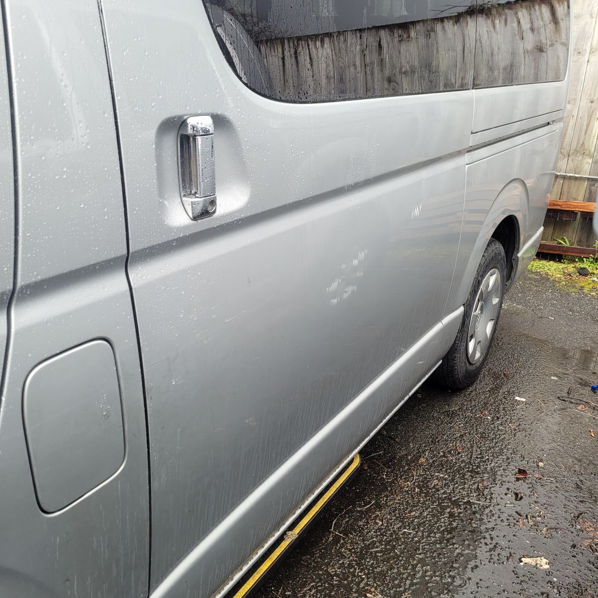 Wet Silver Van with Sliding Door Close-up of a wet silver van's sliding door and handle