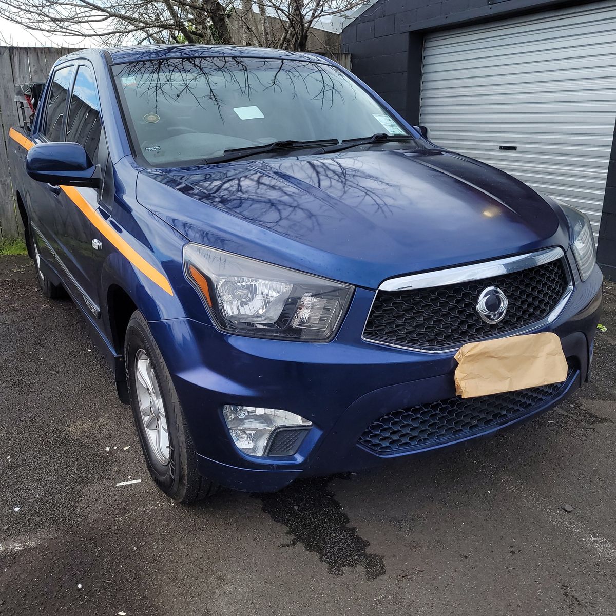 Blue Ssangyong Actyon Sports Utility Truck Parked Outdoors Front view of a blue Ssangyong Actyon Sports truck parked on an asphalt surface.