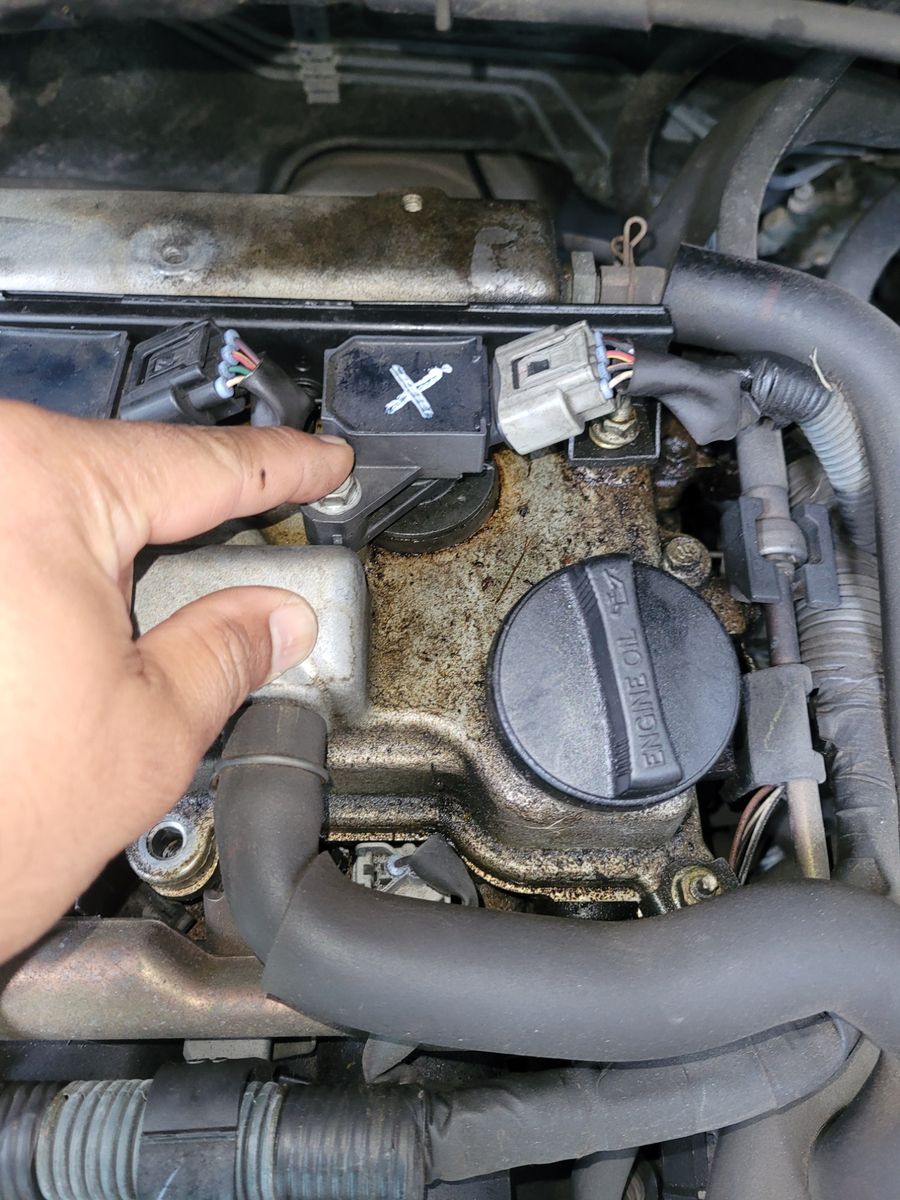 Technician Pointing at Engine Coil During Mechanical Diagnostic Hand pointing at ignition coil on a car engine during mechanical diagnostic.