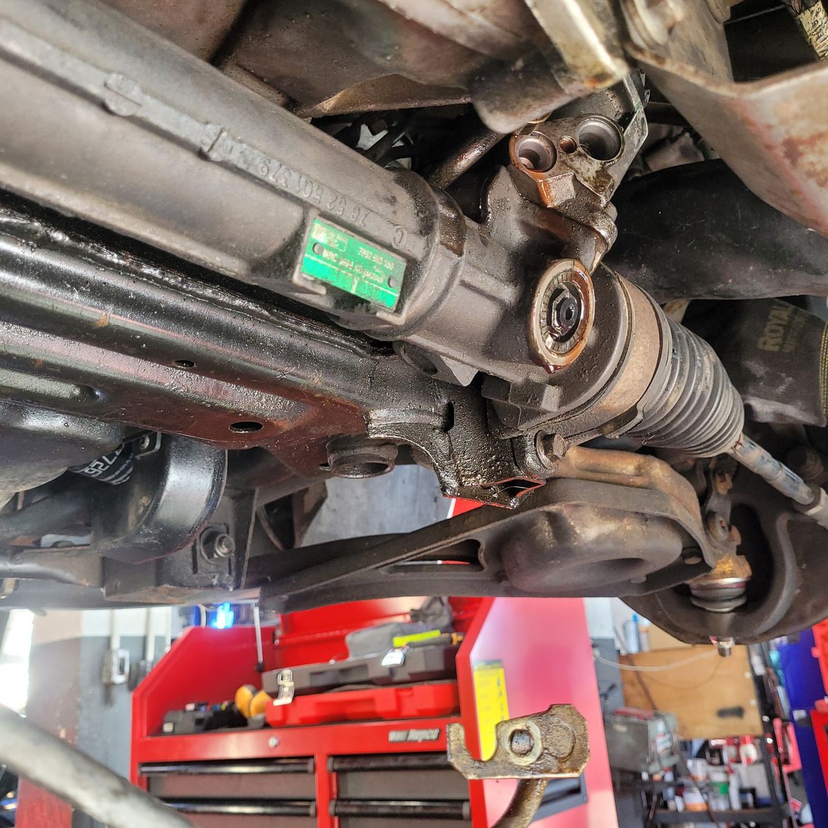 Steering Rack Repair in Progress Close-up of a car's steering rack removed for repair in a workshop