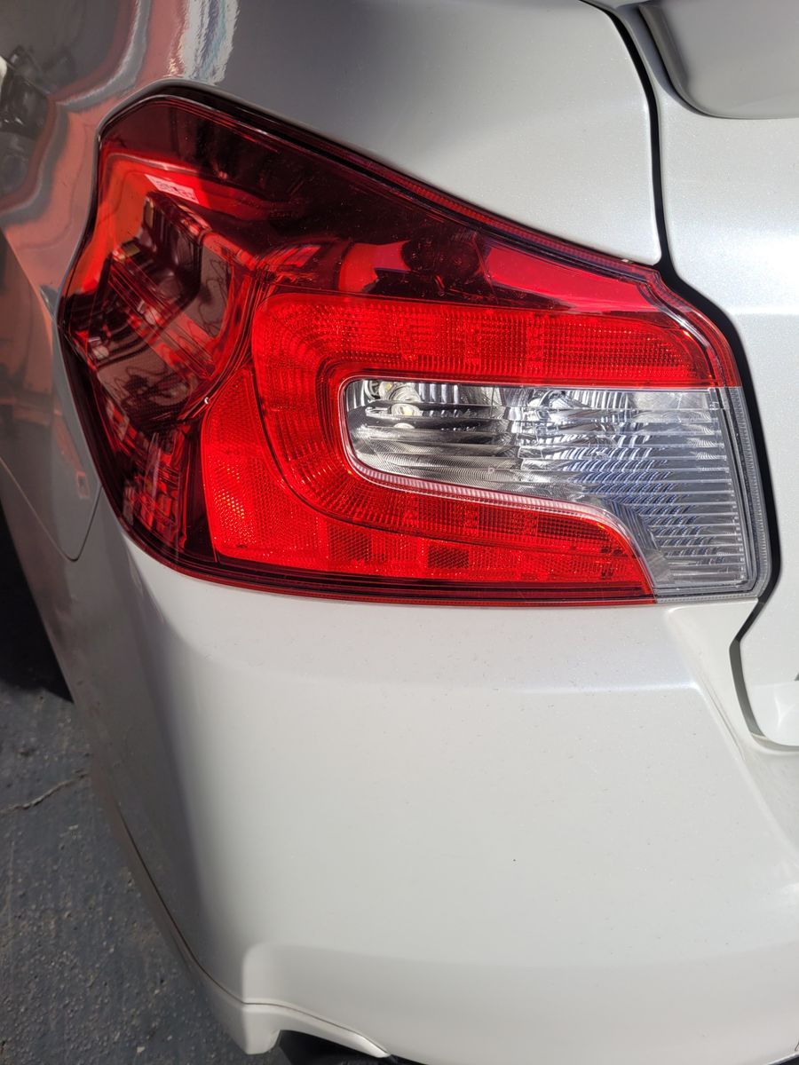 Close-up of a Car Brake Light Red and clear rear brake light on a white car in sunlight