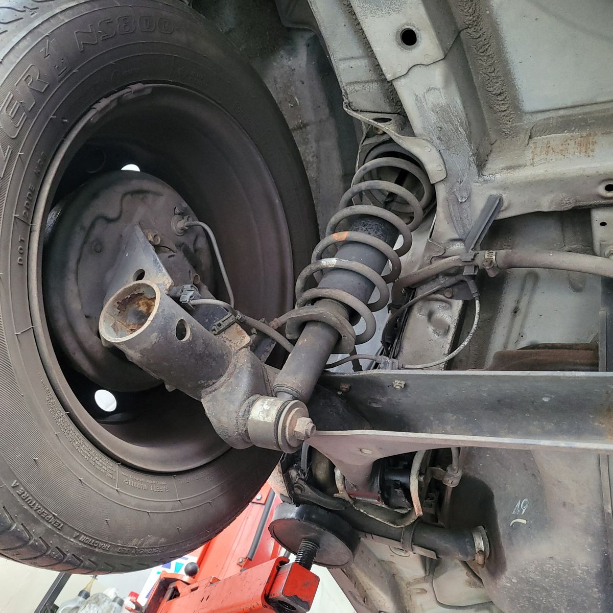 Detailed view of a car's rear suspension system and coil spring.
