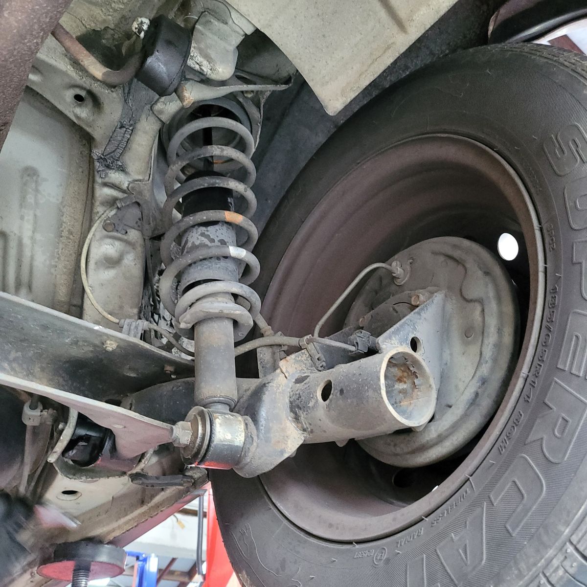 Close-Up of Car Suspension and Tire Car suspension system, coil spring, and attached wheel up close