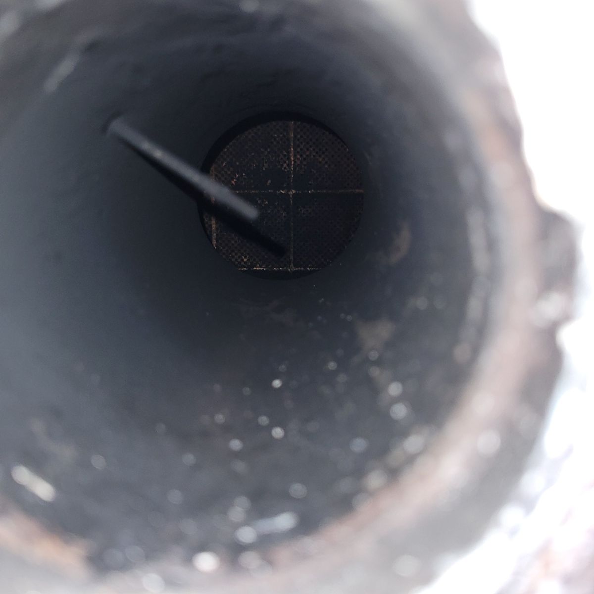 View Inside a Car Exhaust Pipe Showing Signs of Damage Inside view of a car exhaust pipe with soot and possible blockage