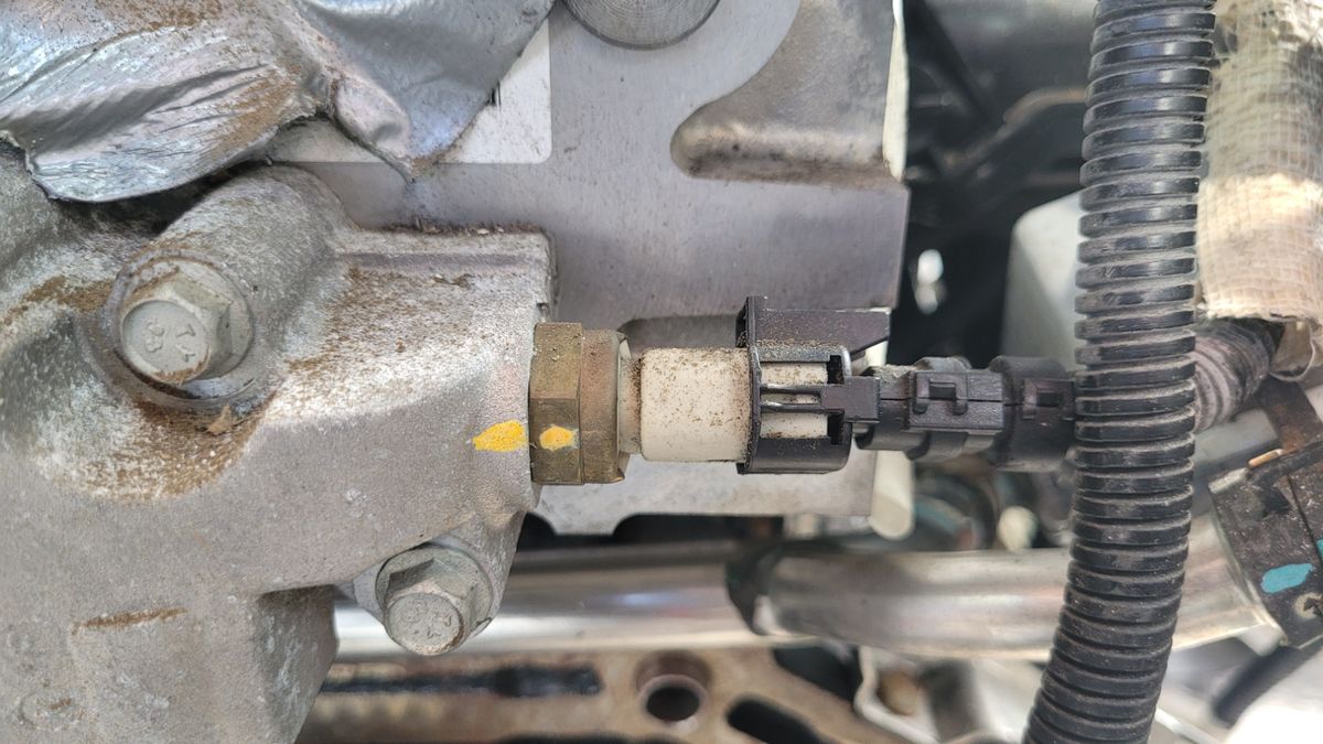 Close-Up of Engine Temperature Sensor Engine temperature sensor connected to wiring harness on metal engine block.