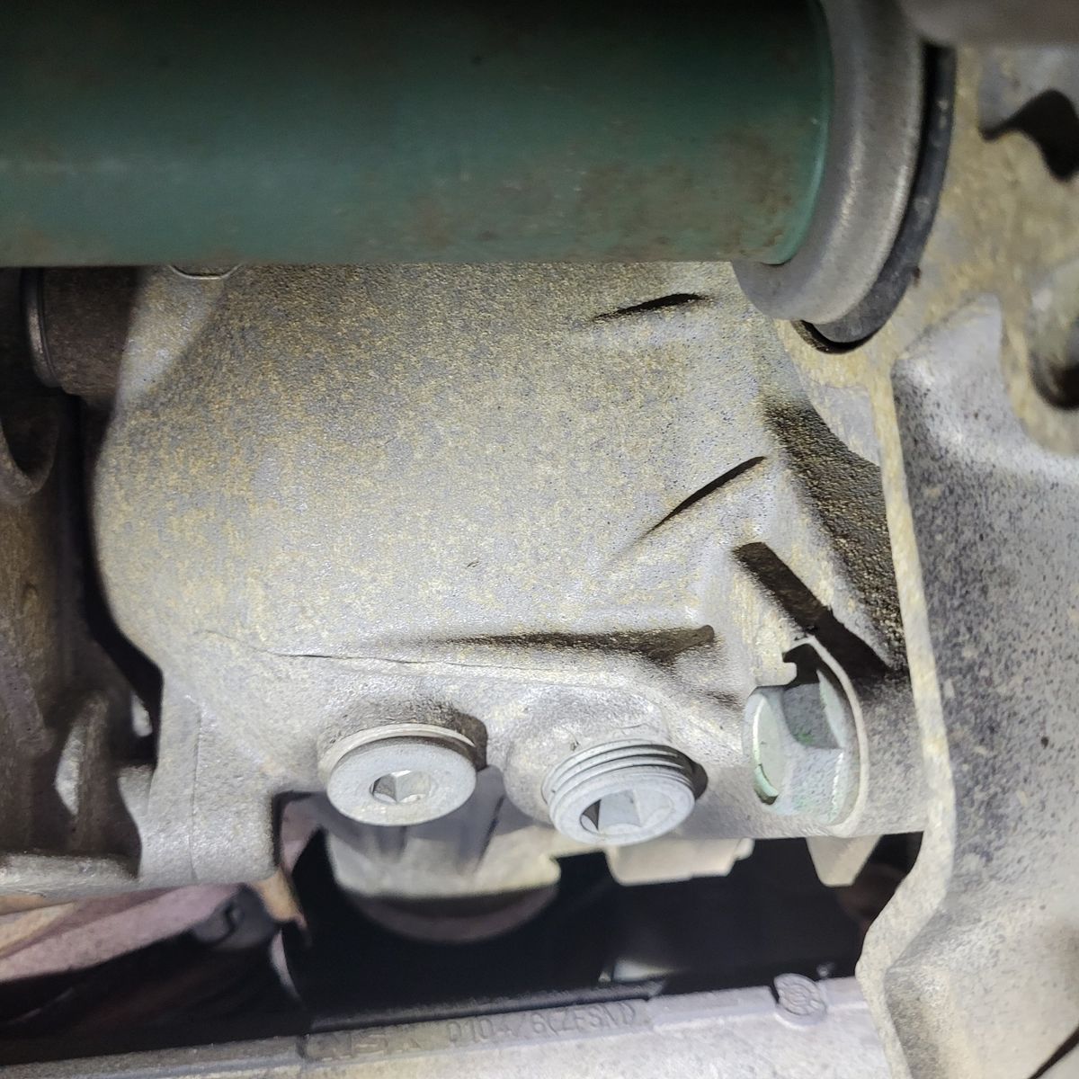 Close-Up of Vehicle Transfer Case Fluid Drain Plugs View of transfer case with drain and fill plugs on vehicle underside.