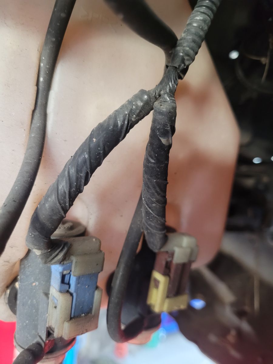 Close-Up of Washer Bottle Pump Connectors Electrical connectors attached to a washer bottle pump under a car hood