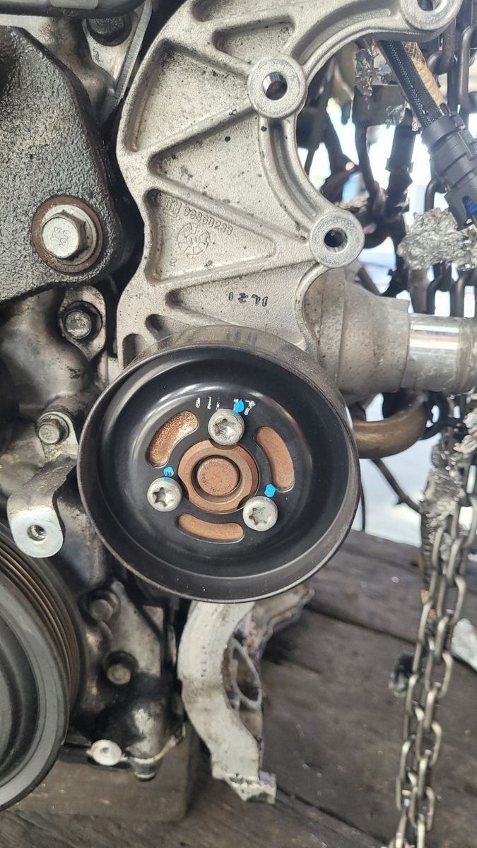 Close-Up of Car Water Pump Assembly Detailed view of an automotive water pump attached to an engine block