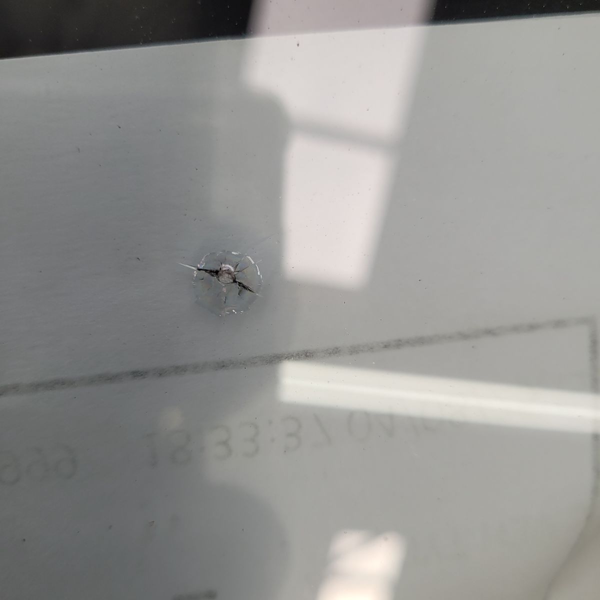 Small Chip and Crack on Windscreen Glass Close-up of a windscreen chip with tiny cracks around it