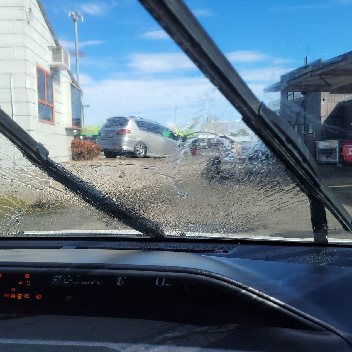 Car Windshield with Wiper Jets in Action View from inside a car as windshield wipers clear sprayed water