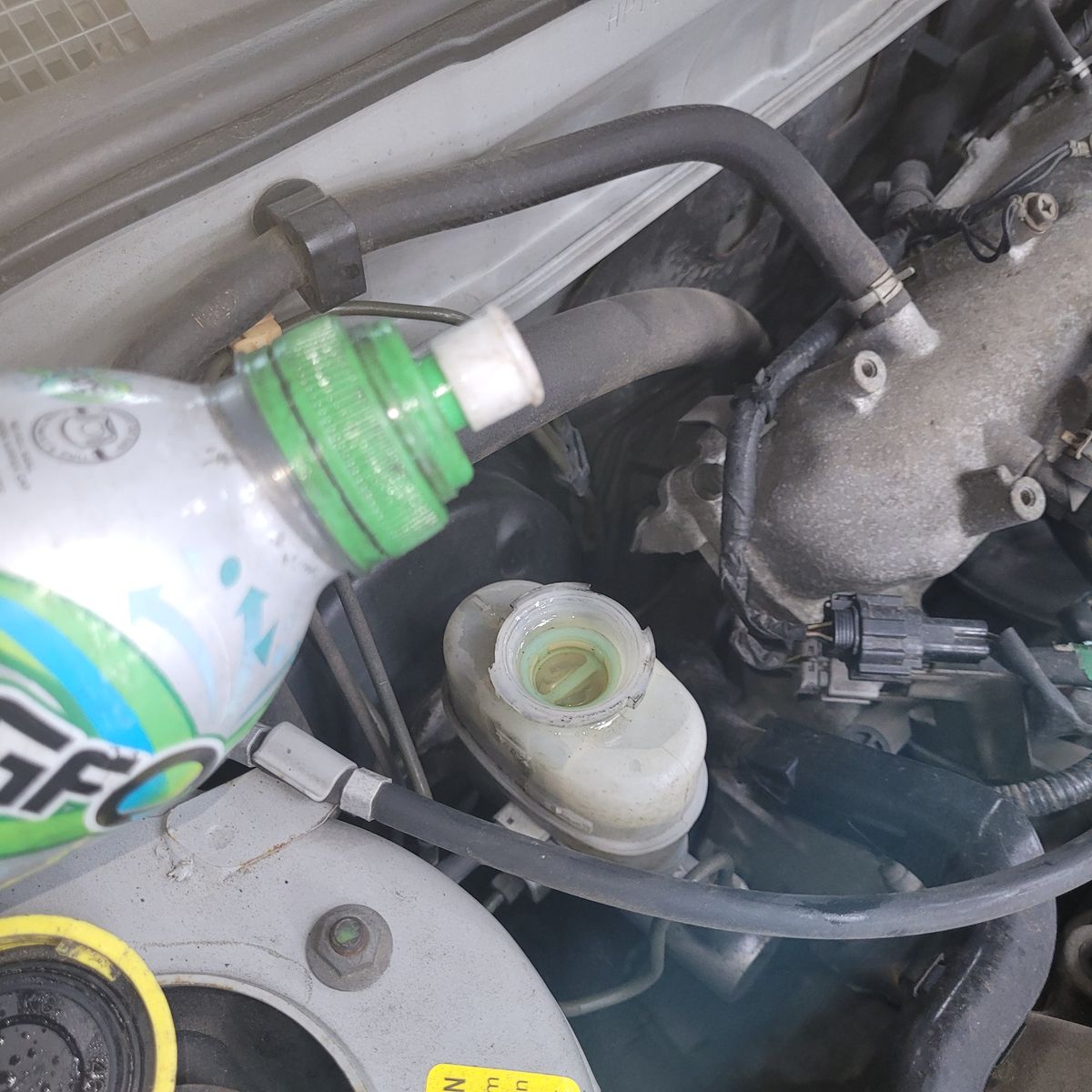 Pouring Brake Fluid into Car Master Cylinder Close-up of brake fluid being poured into a car master cylinder under the hood.