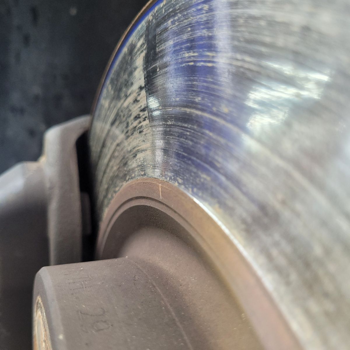 Close-Up of Worn Brake Rotor Detailed view of a car's brake rotor showing heavy wear and scoring.