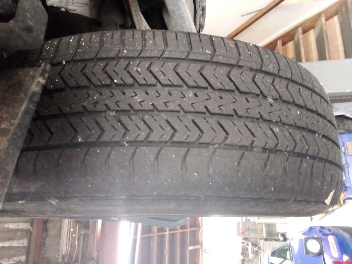 Close-up of a car tyre with significant wear on the outer edge